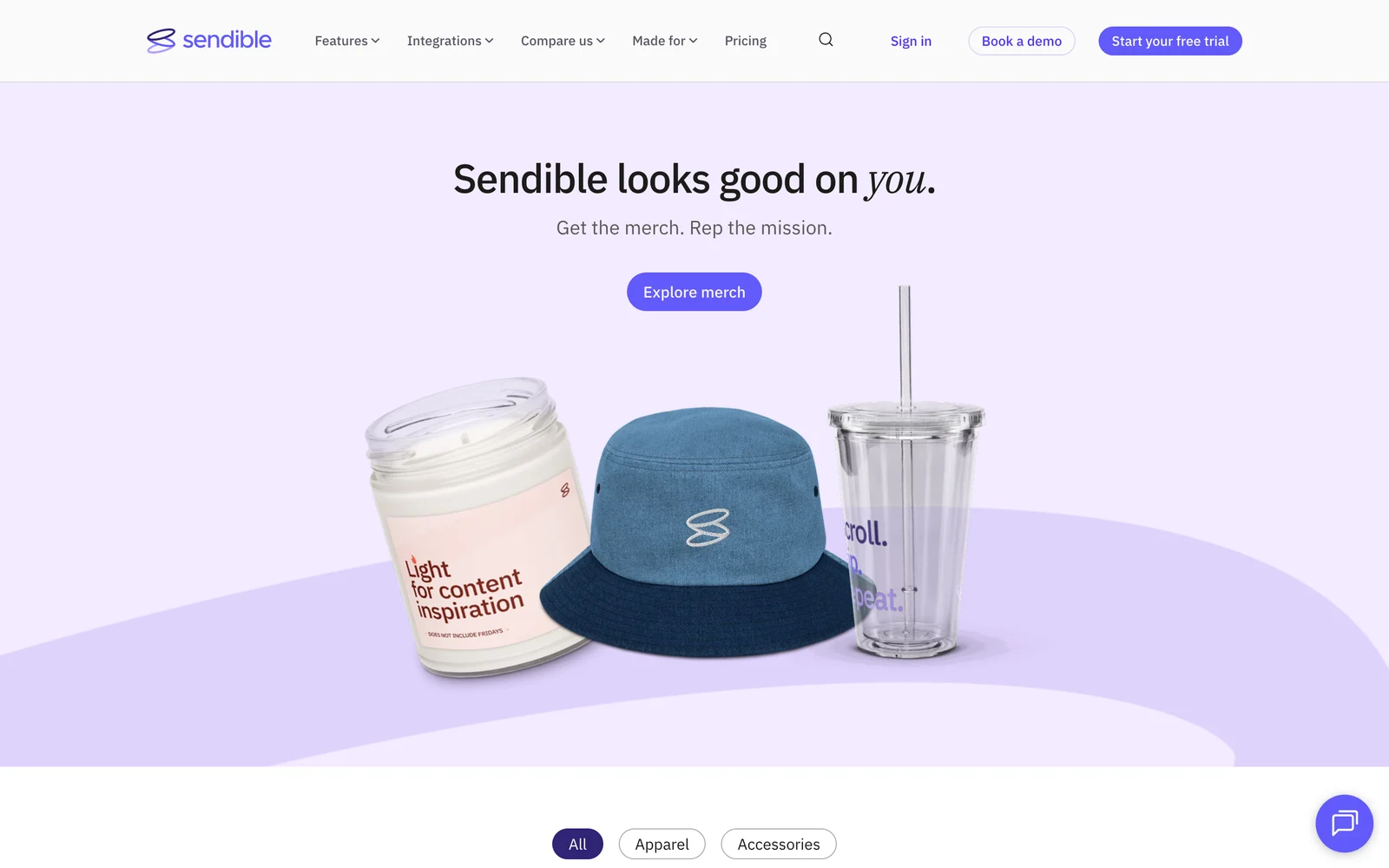 The live Sendible merch page: the italic headline 'Sendible looks good on you,' an Explore merch button, and product shots of a candle, a denim cap and a tumbler, each carrying the new loops mark.